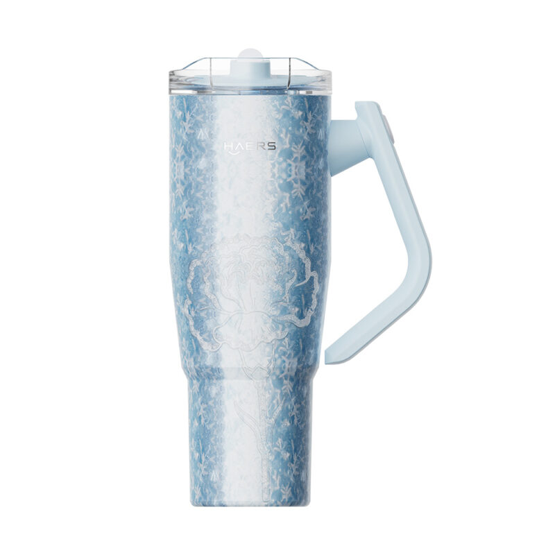 tall light-blue insulated travel mug with a curved handle and clear lid, featuring a subtle white floral pattern.
