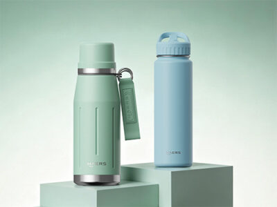 two pastel insulated water bottles on mint-green pedestals, left green with a hanging tag, right light blue with a screw-top lid.